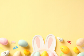 Happy Easter concept. Table serving cutlery and colorful eggs on yellow background