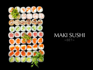 Variety of Japanese Maki sushi roll pieces isolated on black background. Large set with salmon, tuna, shrimp, avocado, cucumber with micro greens on top. Ready banner concept with text, copy space