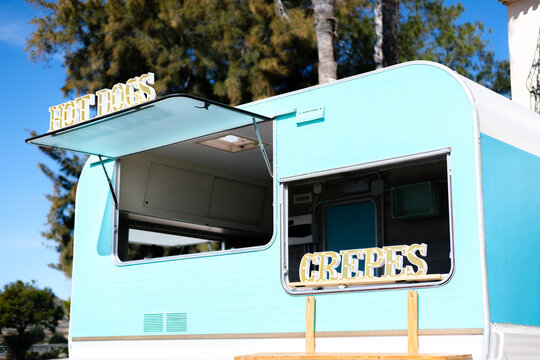 Blue And White Caravan Transformed Into Food Truck With Hot Dog And Crepe Signs