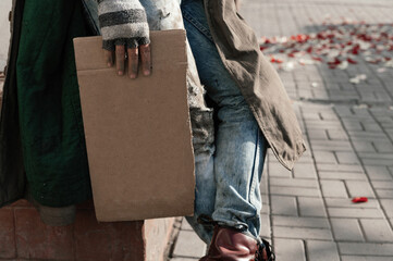 dirty hands of a homeless man with an empty cardboard box