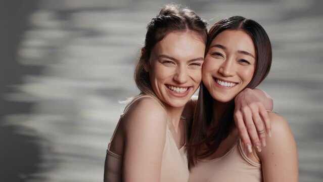 Cheerful beauty models posing on camera for campaign, advertising self acceptance and skincare products. Happy friends with different skintones promoting diversity and body confidence.