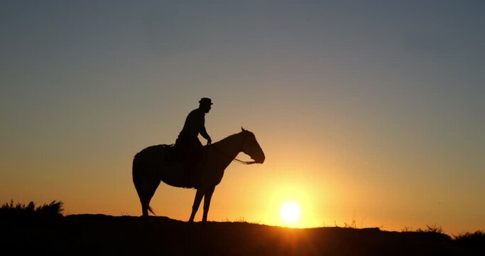 Man on his Camargue Horse Kicking at Sunrise, Manadier in Saintes Maries de la Mer in Camargue, in the South of France , Cow Boy, Slow Motion 4K