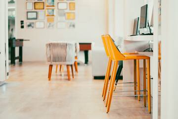 A bright yellow padded chair for typing in the computer in the internet room