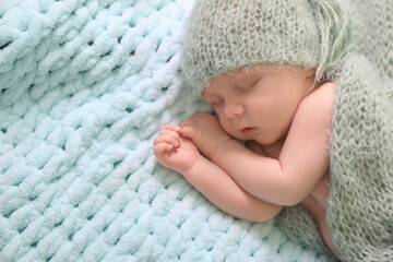 Cute newborn baby sleeping on light blue blanket, top view. Space for text