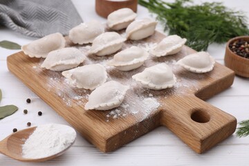 Raw dumplings (varenyky) on white wooden table, closeup