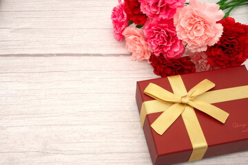 Mother's Day carnations and gifts (wood grain background)