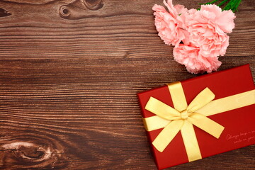 Naklejka na ściany i meble Mother's Day carnations and gifts (wood grain background)
