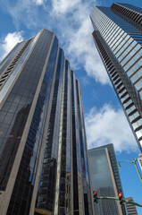 Obraz premium New Skyscrapers with Reflecting Glass Exteriors Under Blue Sky