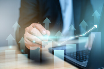 Businessman using laptop and touching  growing  graph on virtual hologram. invest in trading, planning and strategy, Stock market, Business growth, progress or success concept.