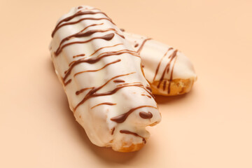 Delicious eclairs on beige background