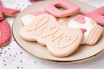 Plate with tasty cookies for Valentine's Day celebration on light table, closeup