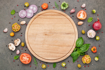 The ingredients for homemade pizza set up on dark stone background.