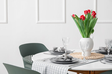 Table setting for International Women's Day celebration with tulip flowers in light room