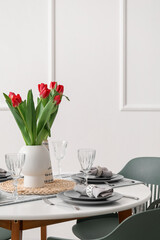 Table setting for International Women's Day celebration with tulip flowers in light room