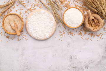 The ingredients for homemade pizza dough with wheat ears ,wheat flour and wheat grains set up on white concrete background.