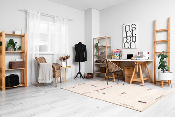 Interior of modern atelier with tailor's workplace, shelving unit and mannequin