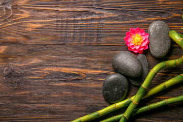 Spa stones and bamboo on wooden background, top view