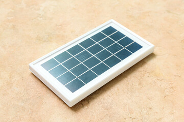 Portable solar panel on beige grunge background