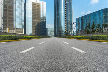 Obraz premium clean road through modern buildings in the city.