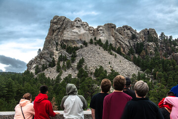 Tourists taking pictures and observe mountain Rushmor with USA presidents sculptures - 576899311
