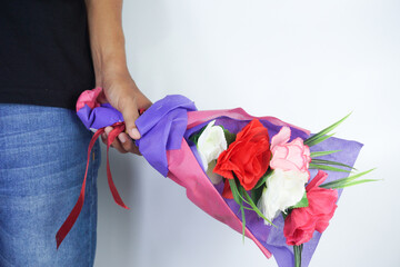 Cropped Hand Of Man Holding Bouquet Against Wall