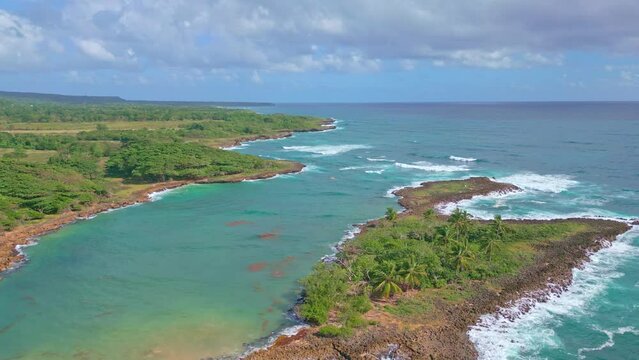 Seascape view over secluded Playa Los Coquitos coastline; aerial pullback