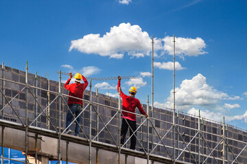 Man working on construction site with scaffold and building with sky background,scaffolding for construction factory