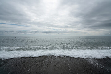 Stormy Black Sea on the Sochi coast and a pebble beach on a cloudy day, Sochi, Krasnodar Territory, Russia