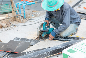 Worker cuts plywood with a circular saw.