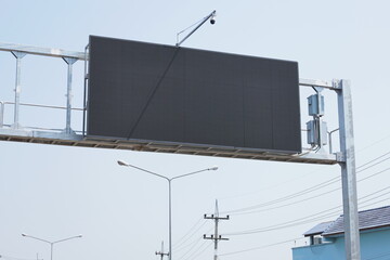 An electronic display on a pillar. Blank LED signpost screen on metal pillar above highway in low...