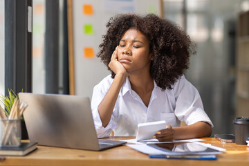 Portrait of tired young business african american woman work with documents tax laptop computer in office. Sad, unhappy, Worried, Depression, or employee life stress concept	
