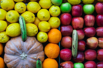 close-up of a shop window with selected fresh fruits: apples, oranges, coconuts, pineapples for a healthy lifestyle