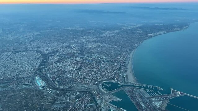 Aerial view of Valencia city, in  SE Spain at sunset, from a jet cockpit. Recorded during the departure from the airport, at 2000m high