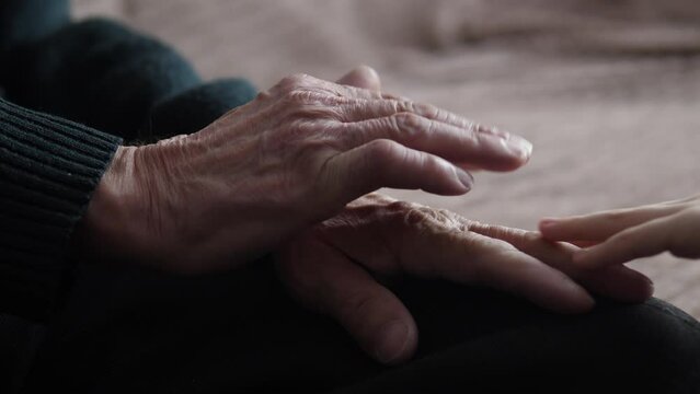close-up of a child's hands hugging the hands of an elderly person.selective focus. wrinkled hands of an old man stroking the hands of a child.