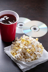 Popcorn with a glass of cola and couple of movies dvd