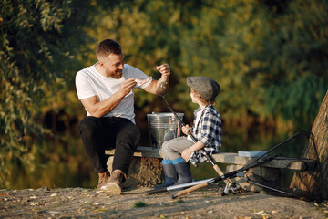 Young father teaching his little toddler son how to fish