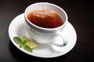 Lemon tea cup with slice of lemon and mint leaf