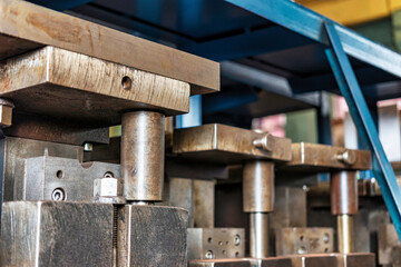 Forms for a hydraulic press on a rack. industrial metalworking machines. Close-up of hydraulic press stamping molds in an industrial workshop at a factory.