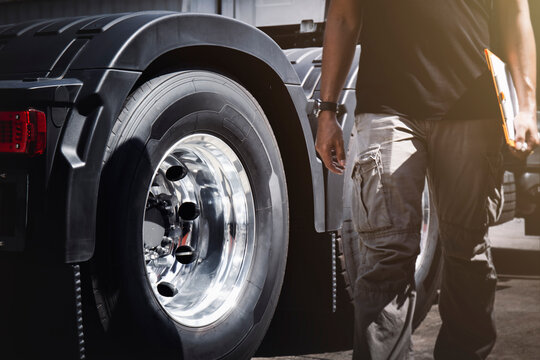 Semi Truck Wheels Tires. Truck Driver is Checking the Truck's Safety of Truck Wheels. Alloy Wheels. Truck Inspection Safety Driving. Work Shop. Auto Maintenance Service	