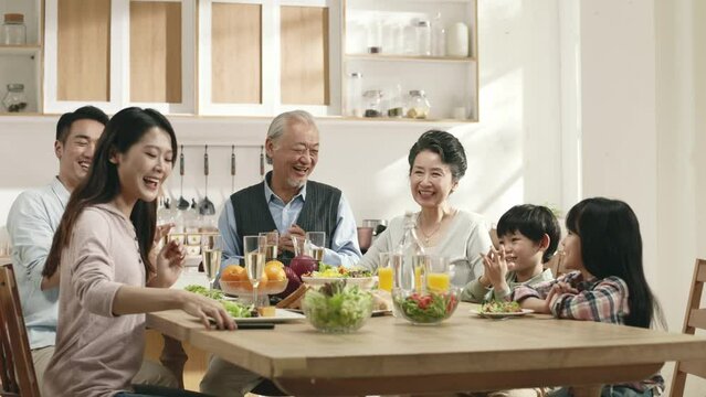 happy three generation asian family taking a selfie during while dining at home