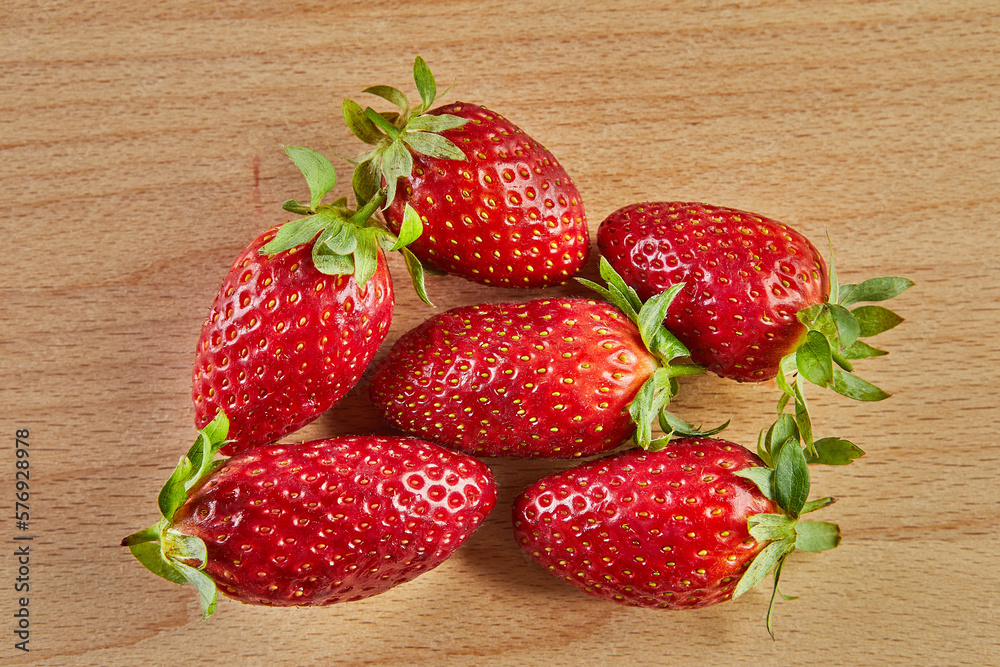 Wall mural Fresh selected strawberries, stacked in slide on wooden background