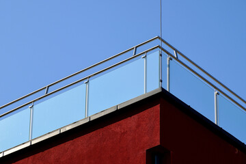 Clear tempered glass balcony balustrade. stainless steel pipe guard rail. building corner. exterior...