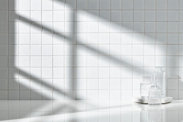 Various objects on a white tile background with warm sunlight shining through
