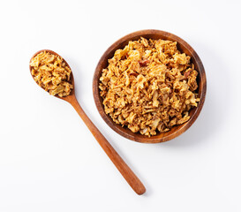 Fried onions and wooden spoon in bowl on white background.