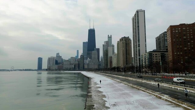 Aerial view following a person walking on the Concrete Beach towards skyscrapers in Streeterville, Chicago, USA