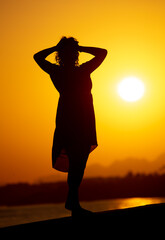 Fototapeta premium Silhouette of a girl on the seashore.