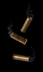 Casing fired with with smoke out of a handgun falling on black background © showcake