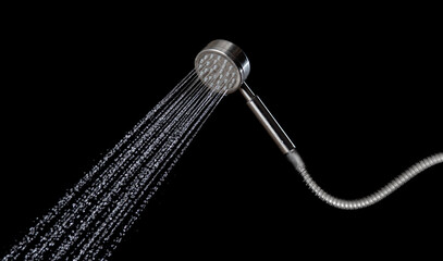 Drop of water coming out of a shower on the black background,Shower working water fly in the air
