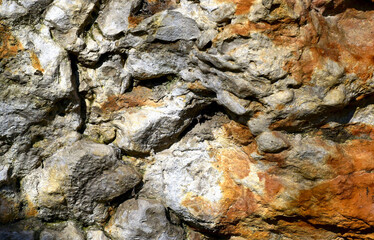 brown and gray stone detail with rustic rough layered split surface and strong sandy texture and grit. stone pattern concept. warm brown tones. background image. natural stone material
