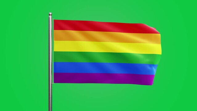A LGBTQ+ rainbow progress pride flag flaps from a flagpole in a brisk breeze. greenscreen  behind, green background 